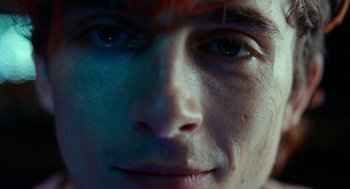 Movie still from “Bones and All” (2022), directed by Luca Guadagnino – A man's face with red hair and blue eyes; Extreme Close Up shot, Overhead angle