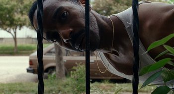 Movie still from “Bones and All” (2022), directed by Luca Guadagnino – A person behind a fence; Close Up shot, Low angle
