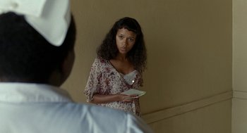 Movie still from “Bones and All” (2022), directed by Luca Guadagnino – A woman holding a plate in front of a mirror; Medium shot, Over the shoulder angle