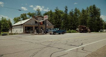 Movie still from “Bones and All” (2022), directed by Luca Guadagnino – A truck parked in front of a building on the side of the road; Extreme Wide shot, High angle