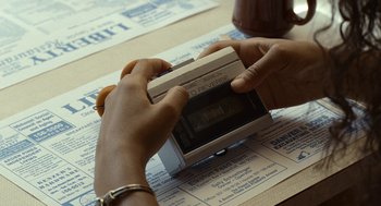 Movie still from “Bones and All” (2022), directed by Luca Guadagnino – A person is holding an electronic device in their hands; Extreme Close Up shot, High angle