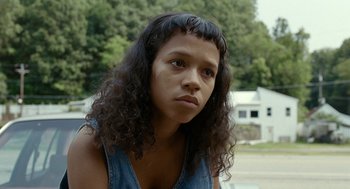 Movie still from “Bones and All” (2022), directed by Luca Guadagnino – A woman with long black hair is looking at the camera; Close Up shot, Low angle