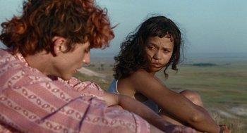 Movie still from “Bones and All” (2022), directed by Luca Guadagnino – Two people sitting on the ground looking at each other; Medium shot, Over the shoulder angle