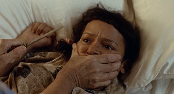 Movie still from “Bones and All” (2022), directed by Luca Guadagnino – A woman covering her face with her hands and covering her mouth with her hands; Close Up shot, High angle