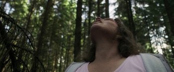 Movie still from “Border” (2018), directed by Ali Abbasi – A woman in the woods looking up into the sky; Close Up shot, Low angle