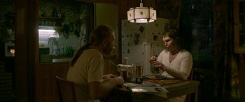 Movie still from “Border” (2018), directed by Ali Abbasi – A man and a woman sitting at a dinner table; Medium shot, High angle