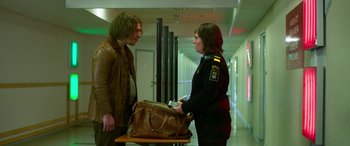 Movie still from “Border” (2018), directed by Ali Abbasi – A man and a woman are holding a brown bag; Medium shot, Low angle