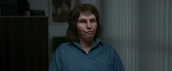 Movie still from “Border” (2018), directed by Ali Abbasi – A person with long hair and a blue shirt; Close Up shot, Low angle