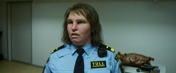 Movie still from “Border” (2018), directed by Ali Abbasi – A man in a police uniform with long brown hair; Close Up shot, Low angle