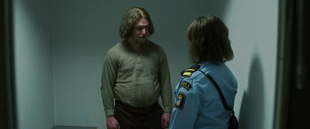 Movie still from “Border” (2018), directed by Ali Abbasi – A man and a woman are standing next to each other; Medium shot, Over the shoulder angle