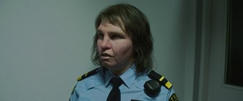 Movie still from “Border” (2018), directed by Ali Abbasi – A woman wearing a uniform and a black tie; Close Up shot, Low angle