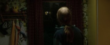 Movie still from “Border” (2018), directed by Ali Abbasi – A woman standing in front of a window at night; Wide shot, Over the shoulder angle