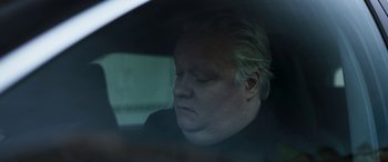 Movie still from “Border” (2018), directed by Ali Abbasi – A man sitting in the back seat of a car; Close Up shot, Low angle