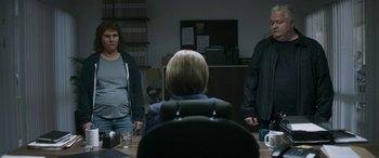 Movie still from “Border” (2018), directed by Ali Abbasi – A group of people standing around a table; Medium shot, Over the shoulder angle