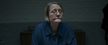 Movie still from “Border” (2018), directed by Ali Abbasi – An older woman wearing glasses and a blue shirt; Close Up shot, High angle