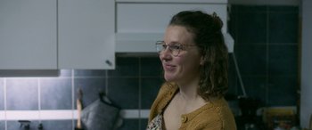 Movie still from “Border” (2018), directed by Ali Abbasi – A woman wearing glasses and a yellow sweater; Close Up shot, Over the shoulder angle