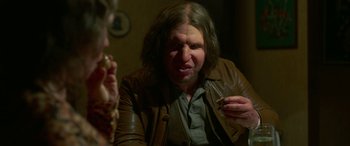 Movie still from “Border” (2018), directed by Ali Abbasi – A man in a brown jacket is holding a cigarette; Close Up shot, Over the shoulder angle