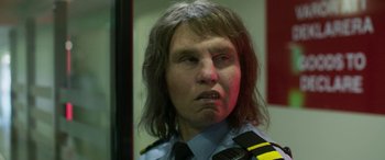 Movie still from “Border” (2018), directed by Ali Abbasi – A man in a police uniform with a frowning look on his face; Close Up shot, Low angle