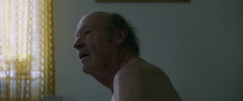 Movie still from “Border” (2018), directed by Ali Abbasi – An older man with a beard and a mustache; Close Up shot, Over the shoulder angle