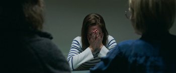 Movie still from “Border” (2018), directed by Ali Abbasi – A woman sitting in front of a wall with her hands covering her face; Close Up shot, Over the shoulder angle