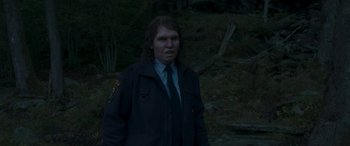 Movie still from “Border” (2018), directed by Ali Abbasi – A man with long dark hair wearing a police uniform; Close Up shot, Over the shoulder angle