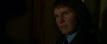 Movie still from “Border” (2018), directed by Ali Abbasi – A man in a suit and tie looking at the camera; Close Up shot, Over the shoulder angle