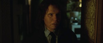 Movie still from “Border” (2018), directed by Ali Abbasi – A person wearing a suit and tie; Close Up shot, Over the shoulder angle