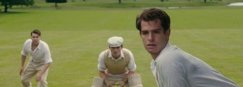 Movie still from “Breathe” (2017), directed by Andy Serkis – Two men are standing in a field and one of them is kneeling down; Close Up shot, Over the shoulder angle
