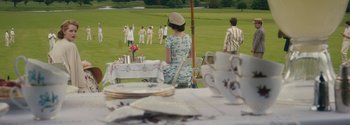 Movie still from “Breathe” (2017), directed by Andy Serkis – A woman sitting at a table in front of a group of people; Extreme Wide shot, High angle