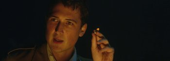 Movie still from “Breathe” (2017), directed by Andy Serkis – A young man holding a lit cigarette in his hand; Close Up shot, Low angle