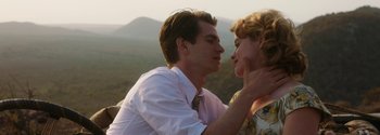 Movie still from “Breathe” (2017), directed by Andy Serkis – A man and a woman kissing on top of a hill; Close Up shot, Low angle