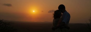 Movie still from “Breathe” (2017), directed by Andy Serkis – Two people standing next to each other in front of the setting sun; Wide shot, Low angle