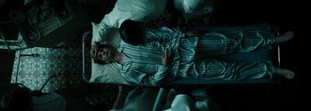 Movie still from “Breathe” (2017), directed by Andy Serkis – A man is lying in a hospital bed; Medium shot, Overhead angle