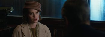 Movie still from “Breathe” (2017), directed by Andy Serkis – A woman wearing a hat is looking at a man in a suit; Close Up shot, Over the shoulder angle