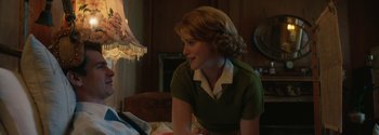 Movie still from “Breathe” (2017), directed by Andy Serkis – A woman sitting on a bed looking at a book; Medium shot, Over the shoulder angle