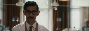 A person wearing glasses and a white coat