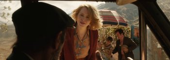 Movie still from “Breathe” (2017), directed by Andy Serkis – A woman with blonde curly hair wearing a floral print shirt; Close Up shot, Over the shoulder angle