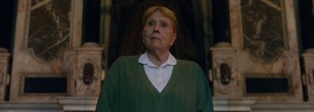 Movie still from “Breathe” (2017), directed by Andy Serkis – An older woman wearing a green sweater looking up; Close Up shot, Low angle
