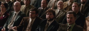 Movie still from “Breathe” (2017), directed by Andy Serkis – A group of men in suits and ties sitting next to each other; Medium shot, Over the shoulder angle