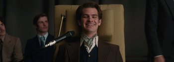 Movie still from “Breathe” (2017), directed by Andy Serkis – A man sitting in a chair with a microphone in front of him; Close Up shot, Low angle