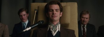 Movie still from “Breathe” (2017), directed by Andy Serkis – A man in a brown suit with a microphone; Close Up shot, Overhead angle