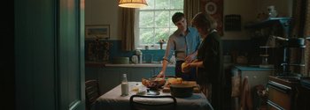 Movie still from “Breathe” (2017), directed by Andy Serkis – A man and a woman preparing food in a kitchen; Medium shot, Over the shoulder angle