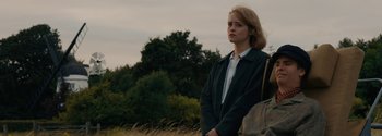 Movie still from “Breathe” (2017), directed by Andy Serkis – A woman standing in front of a tree in a field; Medium shot, Low angle