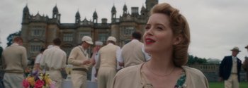 Movie still from “Breathe” (2017), directed by Andy Serkis – A woman standing in front of a group of people; Close Up shot, Over the shoulder angle