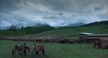 Movie still from “Brokeback Mountain” (2005), directed by Ang Lee – A group of people standing on top of a lush green field; Extreme Wide shot, High angle