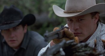 Movie still from “Brokeback Mountain” (2005), directed by Ang Lee – A man in a cowboy hat is holding a rifle; Close Up shot, Over the shoulder angle