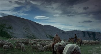 Movie still from “Brokeback Mountain” (2005), directed by Ang Lee – A herd of sheep being herded by two men on horseback; Extreme Wide shot, High angle