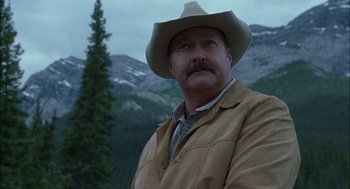Movie still from “Brokeback Mountain” (2005), directed by Ang Lee – A man in a cowboy hat standing in front of a mountain; Close Up shot, Low angle