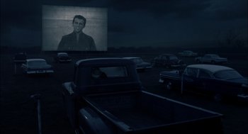 Movie still from “Brokeback Mountain” (2005), directed by Ang Lee – An old truck is parked in front of a drive - in movie screen; Wide shot, Over the shoulder angle