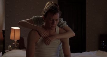 Movie still from “Brokeback Mountain” (2005), directed by Ang Lee – A woman is holding a man's arm over his chest; Medium shot, High angle